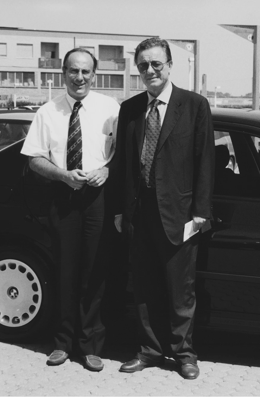 Due uomini accanto a un'auto nel piazzale Lucar, anni '90