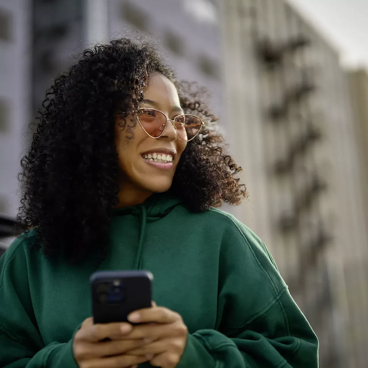 Ragazza sorridente con lo smartphone in mano