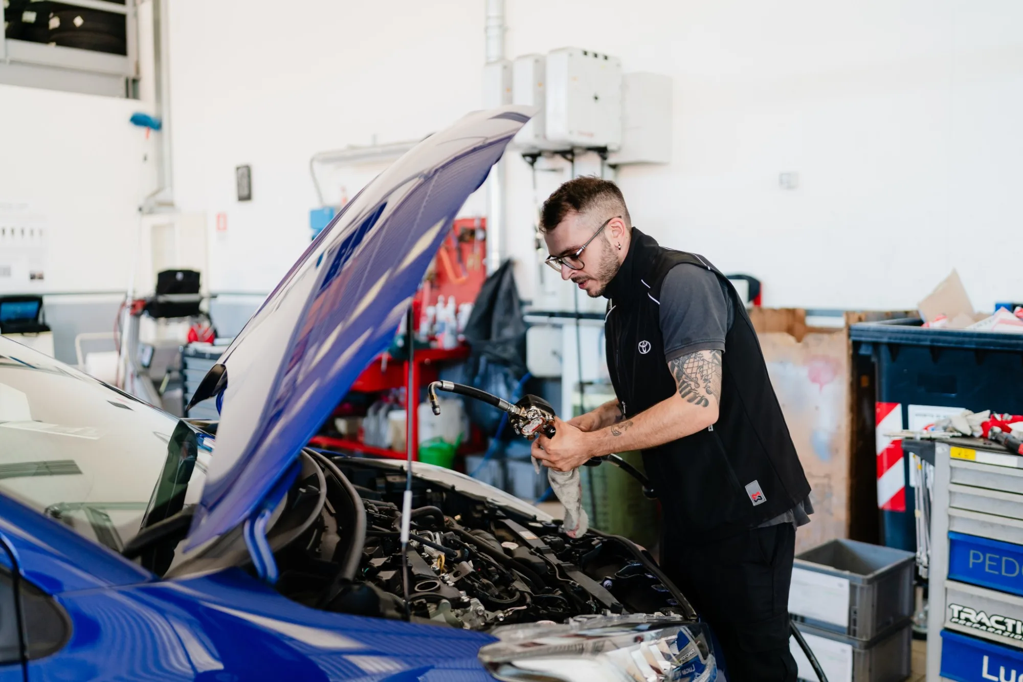 Tecnico Lucar al lavoro nel vano motore di una Toyota blu